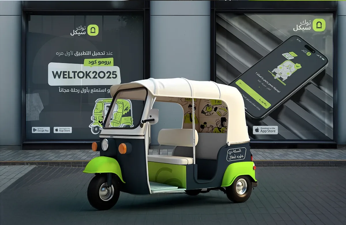 A tuk-tuk wrapped in Tukcycle navy and lime in front of a shop window with the WELTOK2025 first-ride promo